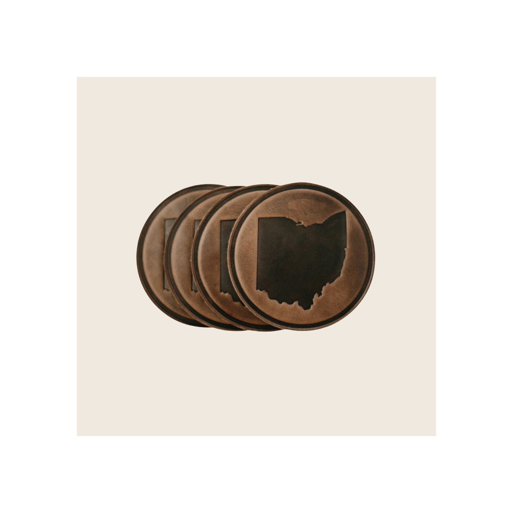 Set of four round brown leather coasters with debossed Ohio state silhouette, stacked diagonally
