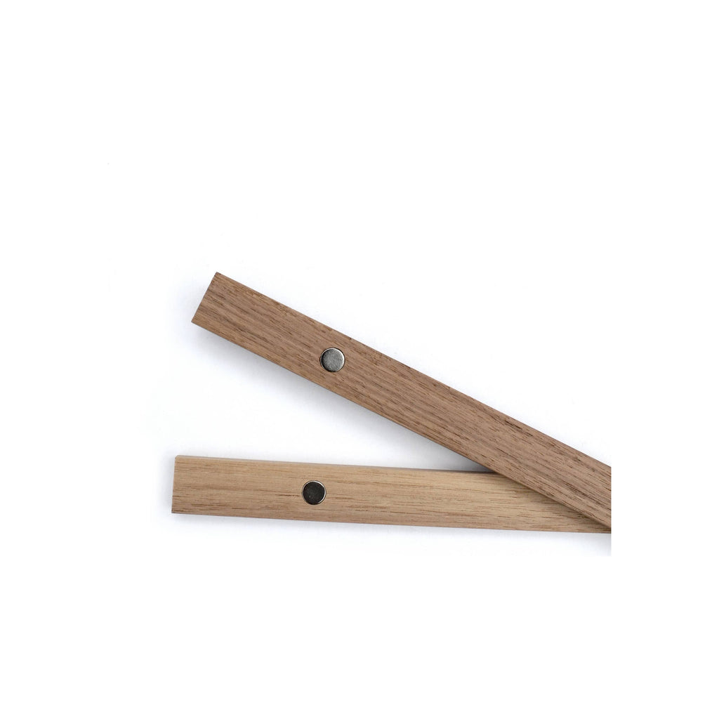 Two oak wood magnetic poster frame rails with silver circular magnets, diagonal orientation