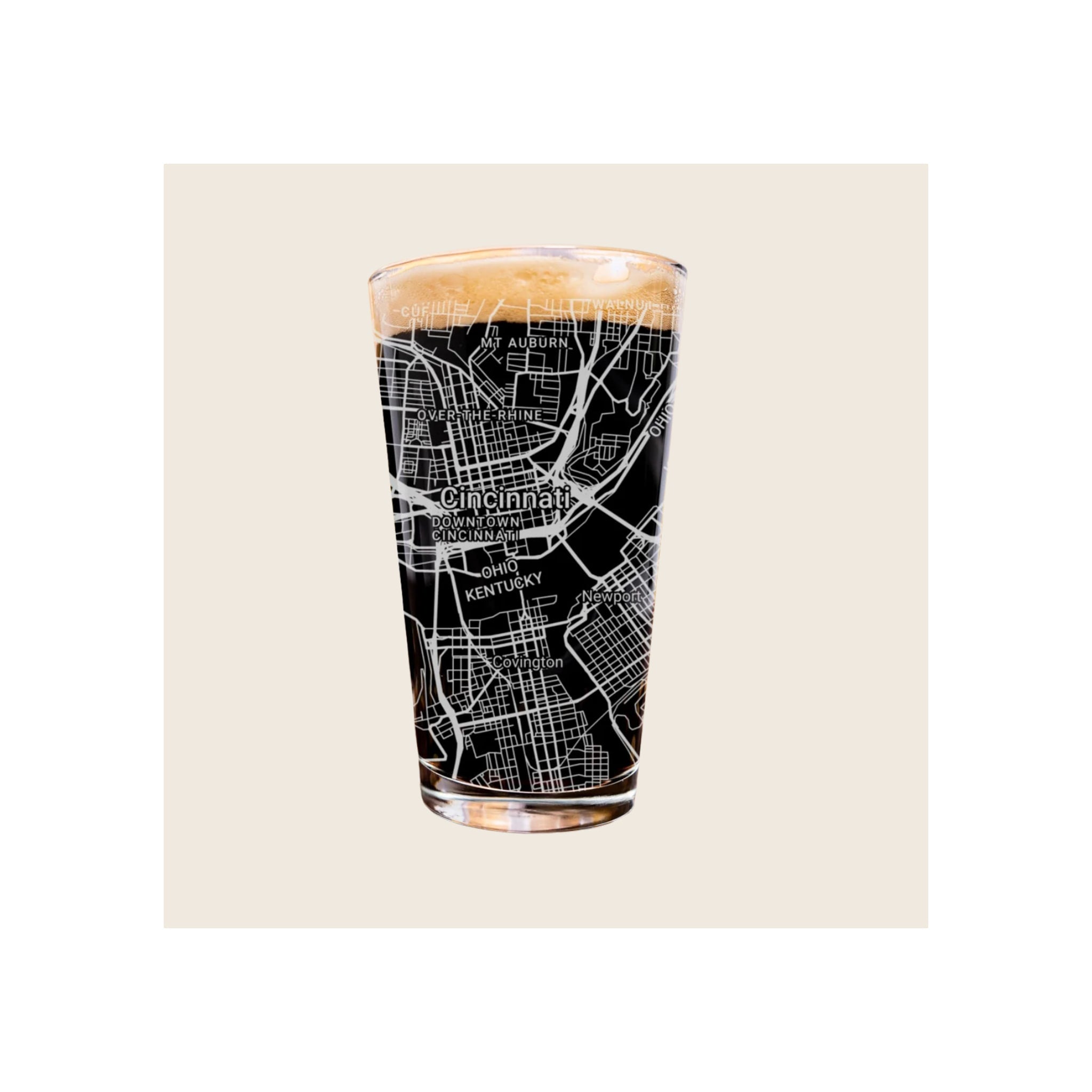 Pint glass with black Cincinnati city map etching, filled with dark beer and foam head