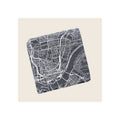 Square slate coaster engraved with white Cincinnati city map, angled view on beige background