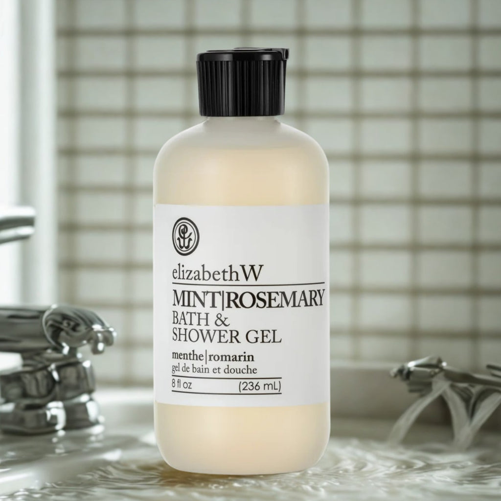 Shower gel bottle, cream frosted plastic with black flip cap, upright on wet bathroom sink surface