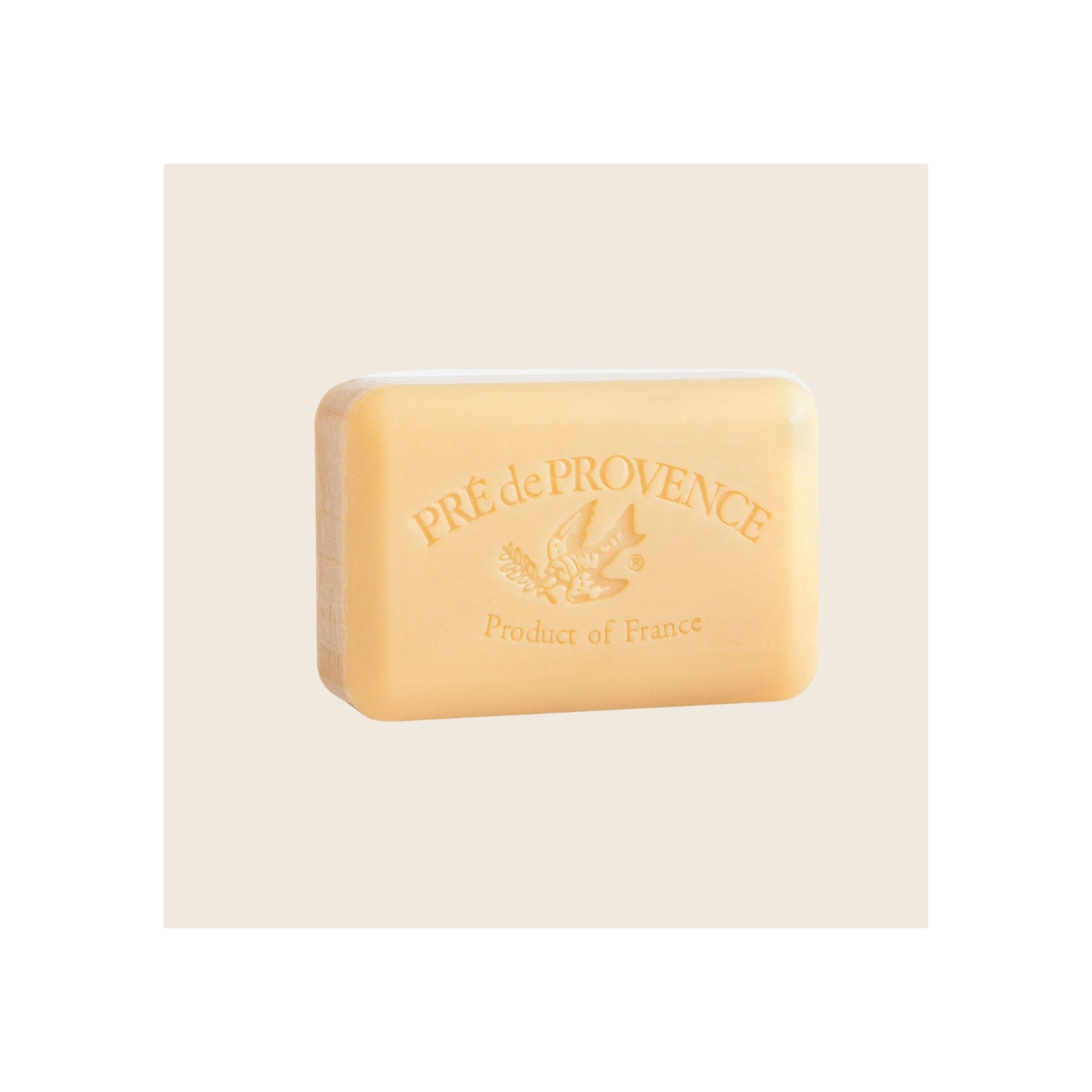 Soap bar, pale golden-yellow rectangular shape, embossed Pré de Provence branding and bird motif, angled front view