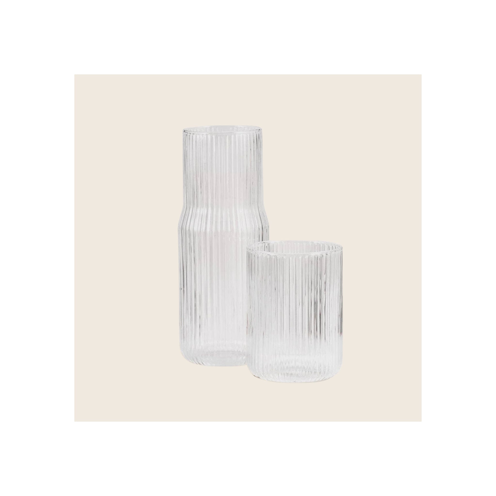 Ribbed clear glass carafe and matching tumbler, vertical ribbed texture, upright front-facing orientation