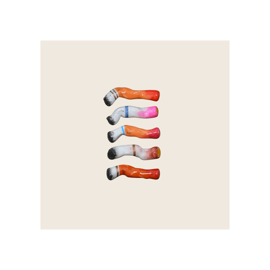 Five ceramic cigarette butts, assorted colors, lipstick-stained tips, arranged vertically on light background