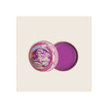 Lip balm tin, open, pink floral illustrated lid beside purple balm-filled base
