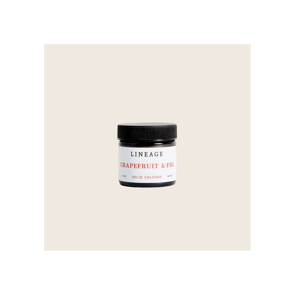 Solid cologne jar, amber glass with black screw-top lid, white label, front-facing upright