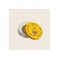 Hair styling paste tin, open lid leaning against jar, yellow with blue text, white cream product visible