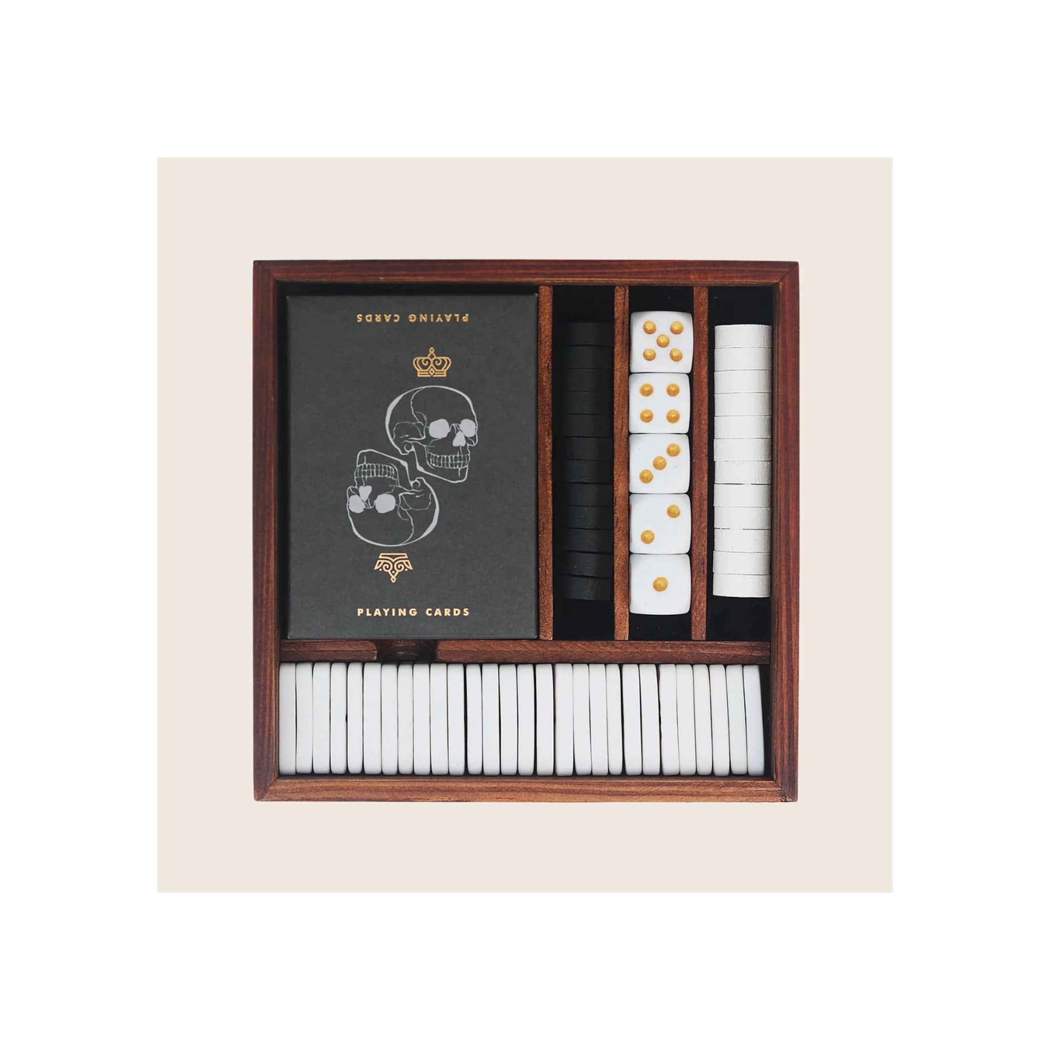 Wooden games compendium box open top-down, containing skull-design playing cards, white and black poker chips, and white dice with gold pips