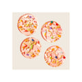 Four round pink resin coasters with embedded colorful pill capsules and gold foil flakes, overhead flat-lay view
