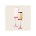 Champagne flutes set of two pink tinted glass with scalloped rims one filled with sparkling wine