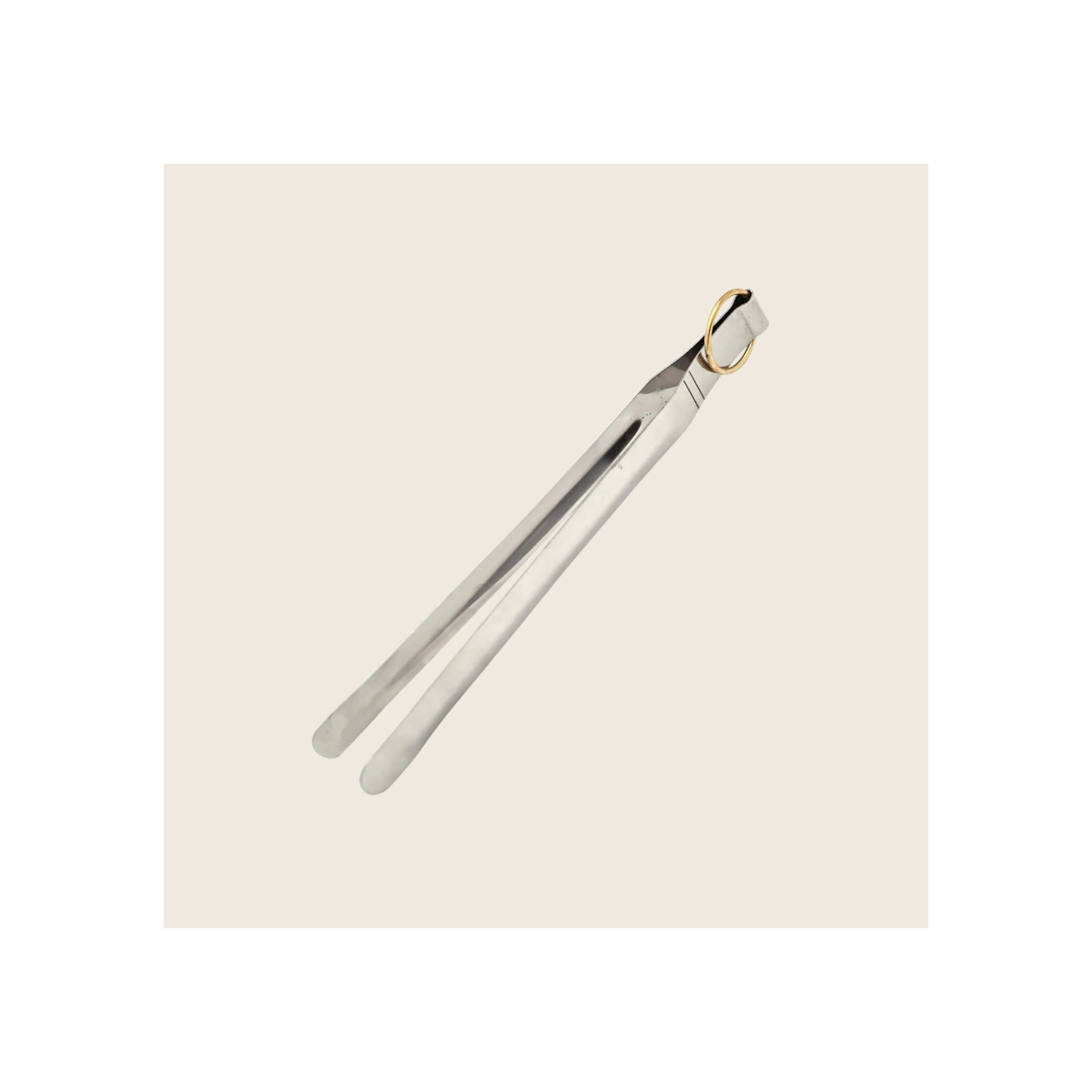 Indian tongs, polished stainless steel with gold-tone brass ring, diagonal orientation