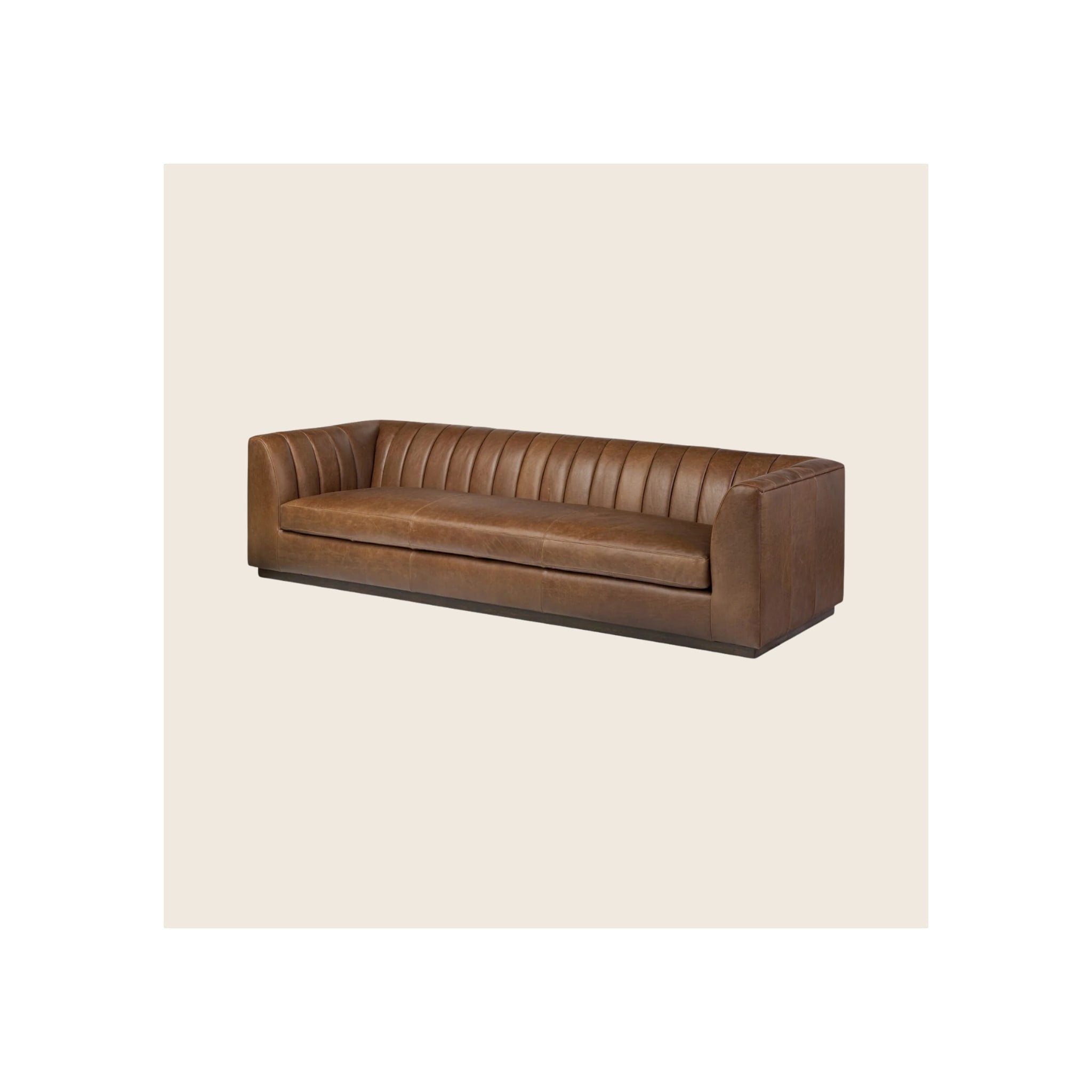 Sofa, brown leather, vertical channel-tufted back, low-profile dark plinth base, angled three-quarter view