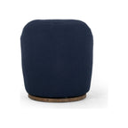 Swivel accent chair in navy bouclé shown from rear, revealing rounded sculptural back and circular wood base