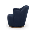 Navy bouclé swivel chair in profile view highlighting curved backrest seam and parawood swivel base