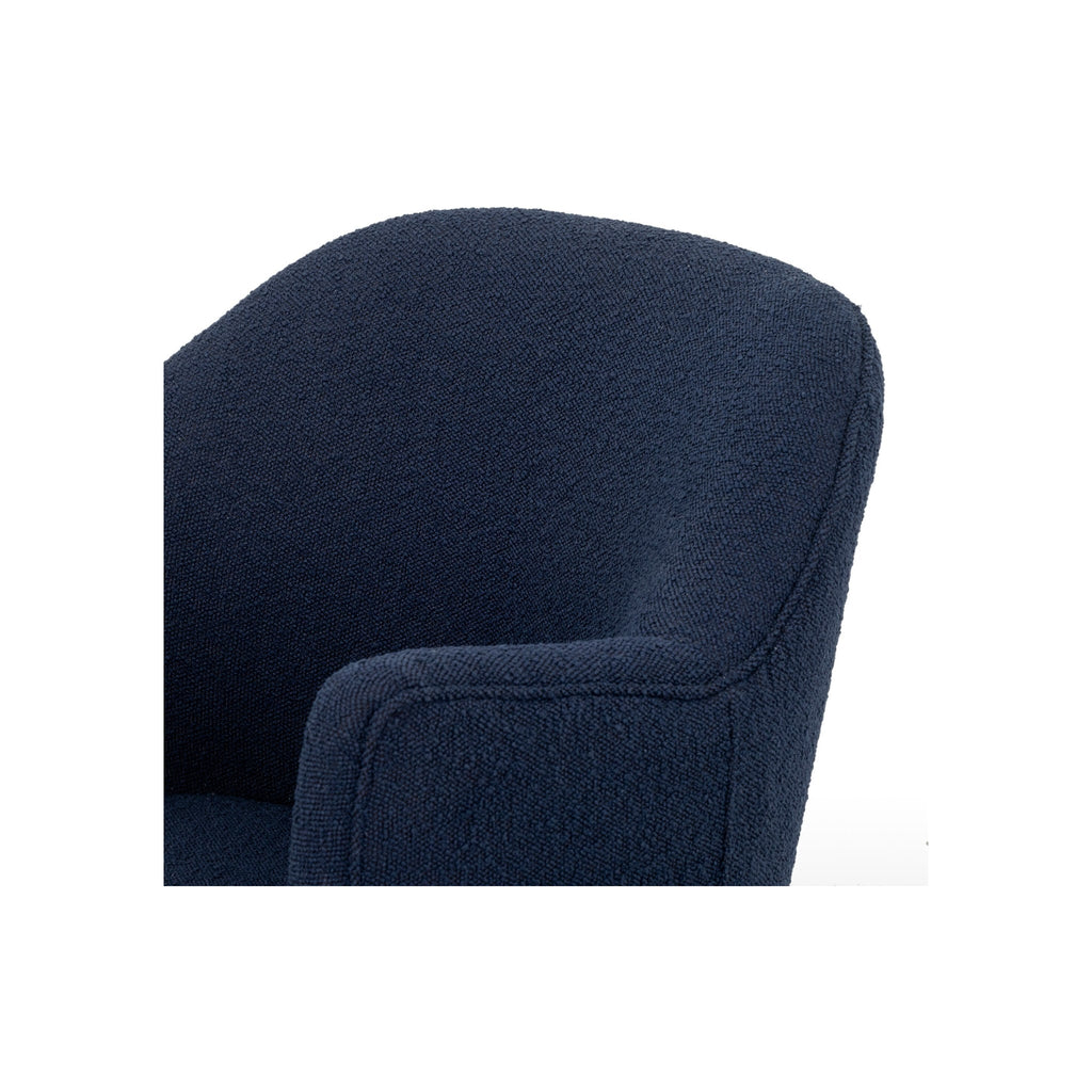 Close-up of navy bouclé chair back and arm junction showing soft rounded upholstery edge detail