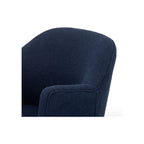Close-up of navy bouclé chair back and arm junction showing soft rounded upholstery edge detail