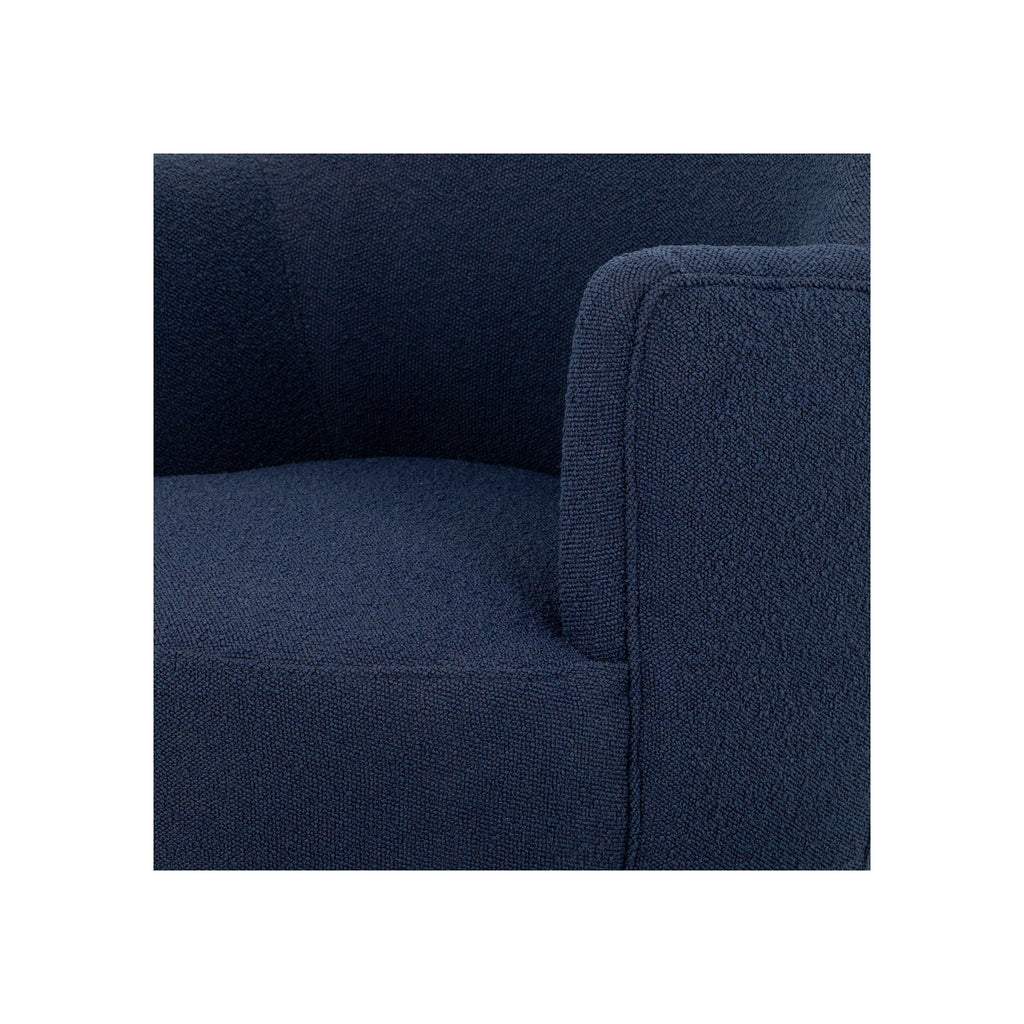 Close-up of navy bouclé arm and seat corner showing tight woven texture and clean upholstery seam