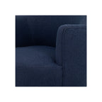 Close-up of navy bouclé arm and seat corner showing tight woven texture and clean upholstery seam