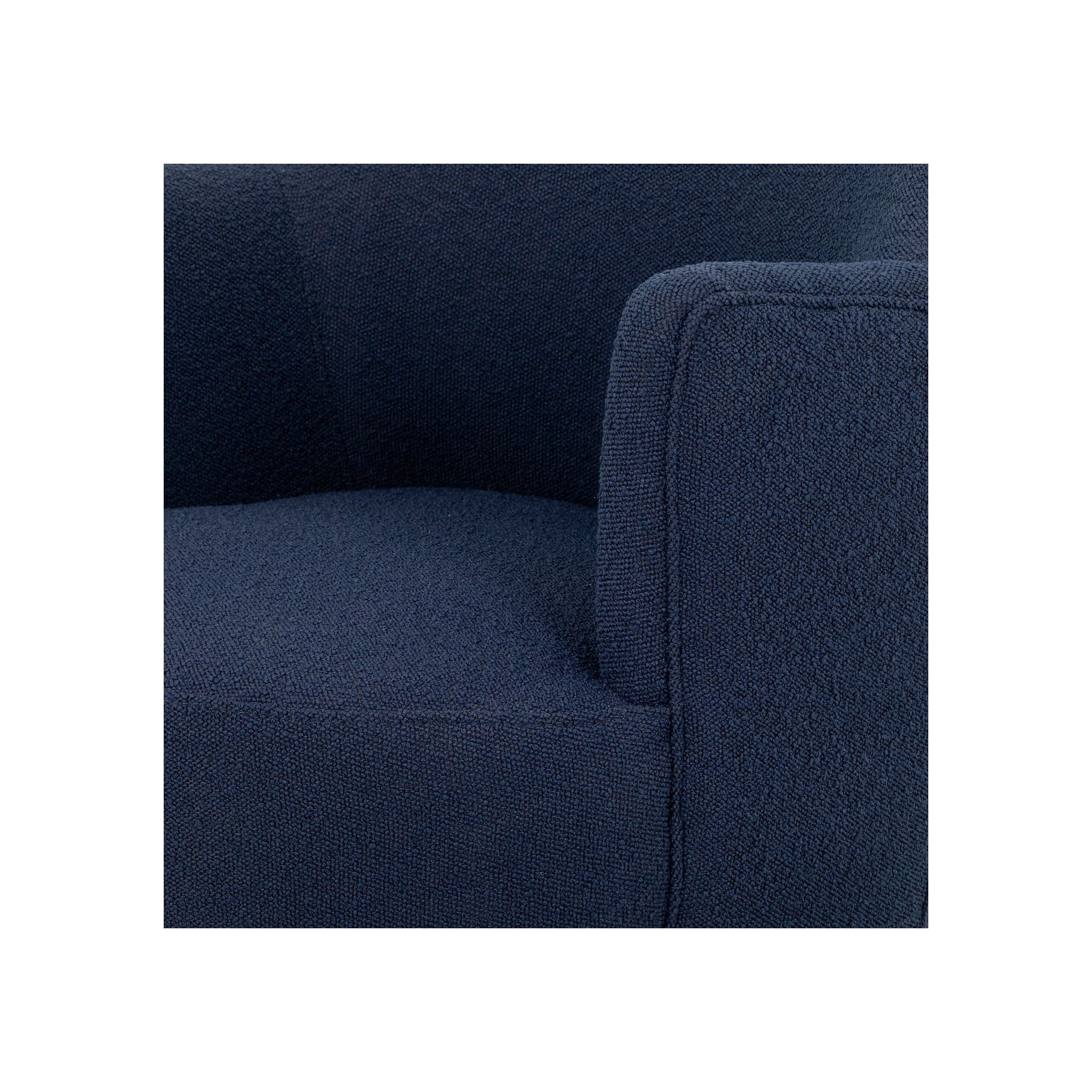 Close-up of navy bouclé arm and seat corner showing tight woven texture and clean upholstery seam