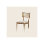 Dining chair with walnut-finish wood frame, cane back panel, and loose cream cushion seat, angled three-quarter view