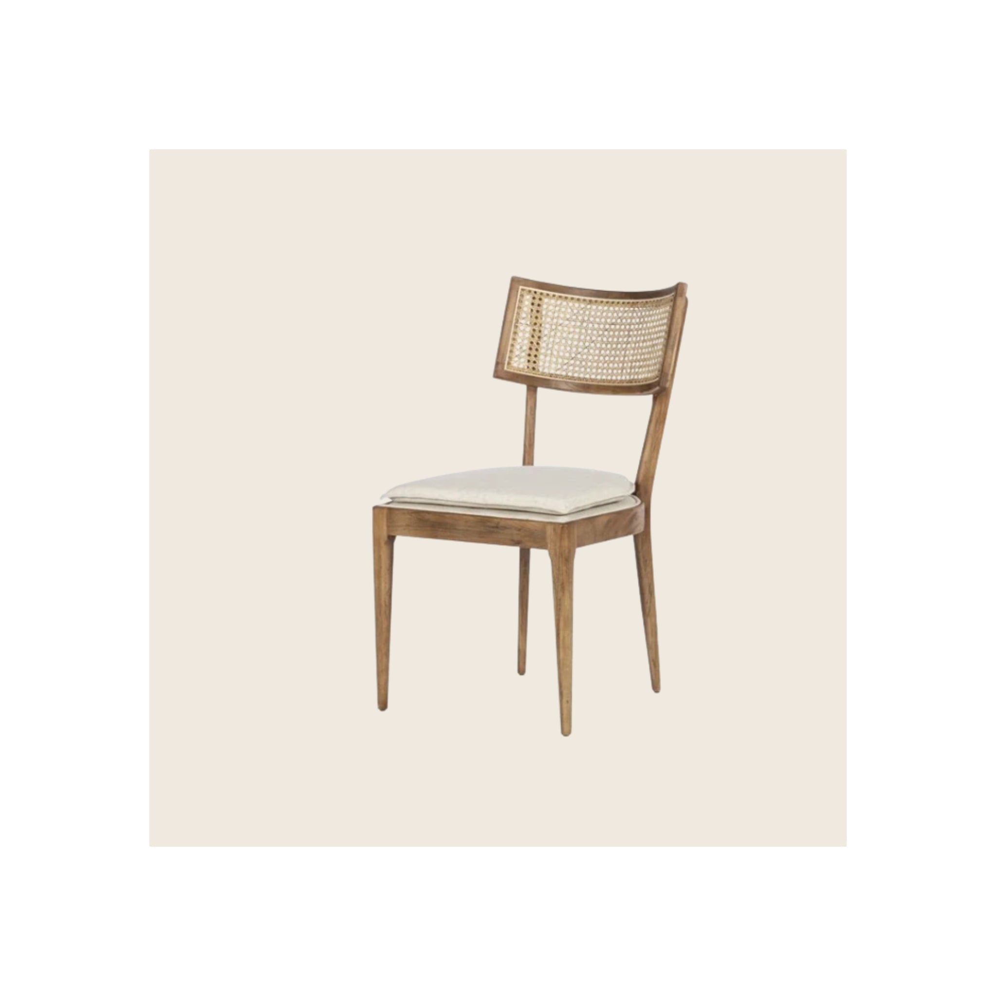 Dining chair with walnut-finish wood frame, cane back panel, and loose cream cushion seat, angled three-quarter view