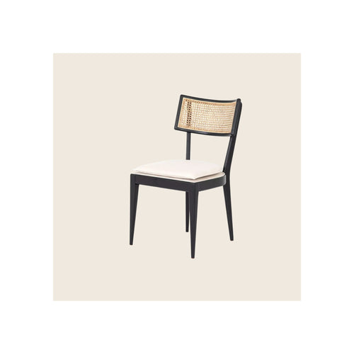 Dining chair with black wood frame, natural cane back panel, and white upholstered seat cushion, angled three-quarter view