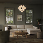 Sectional sofa in light beige fabric with chaise, styled in dark-walled living room