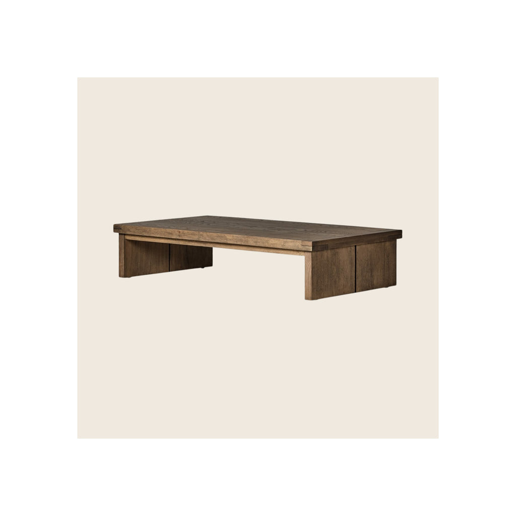 Coffee table in dark brown reclaimed wood finish, low-profile rectangular silhouette, panel legs