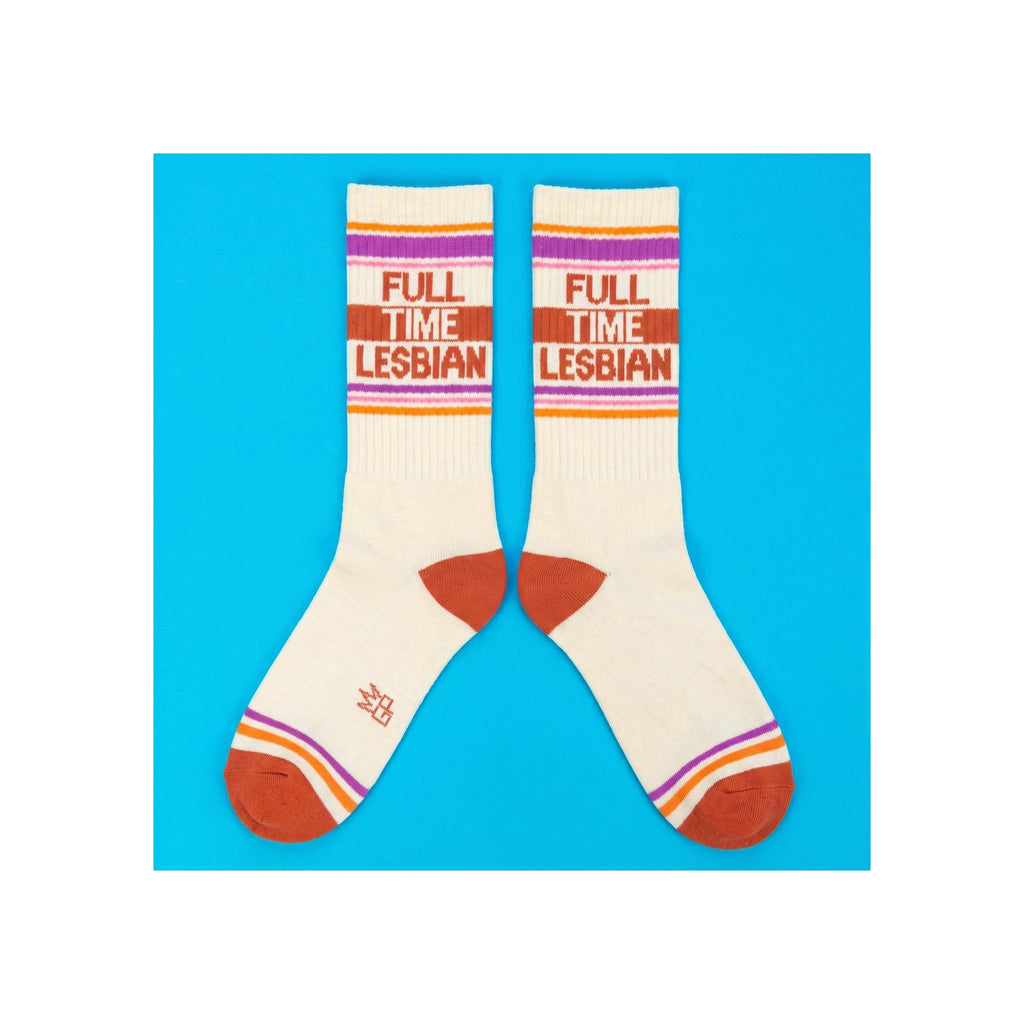Crew socks, cream with orange, purple, and pink stripes, "Full Time Lesbian" knit text, rust toe and heel, flat lay pair