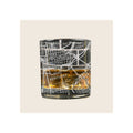 Whiskey glass with engraved Cincinnati street map design, filled with amber liquid, on white background