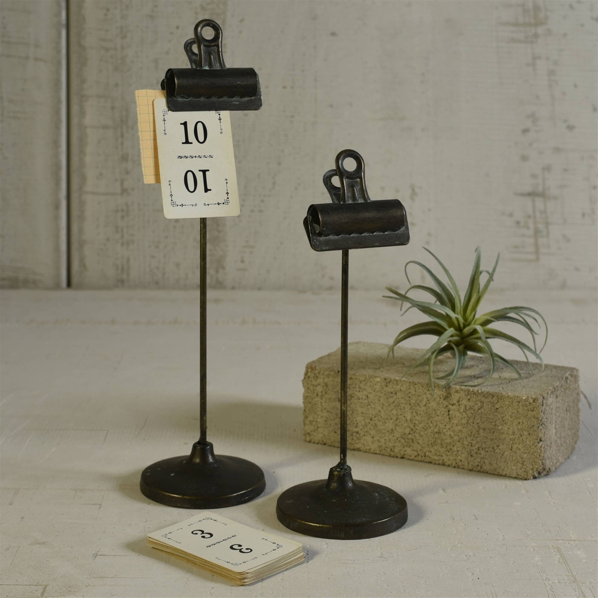 Two black metal clip-on stands, tall and short, with binder-clip tops on round bases