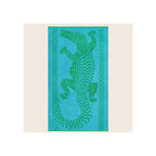 Beach towel in turquoise blue with green woven crocodile and chevron border pattern, laid flat