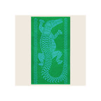 Beach towel in bright green with blue jacquard crocodile and chevron border pattern, laid flat