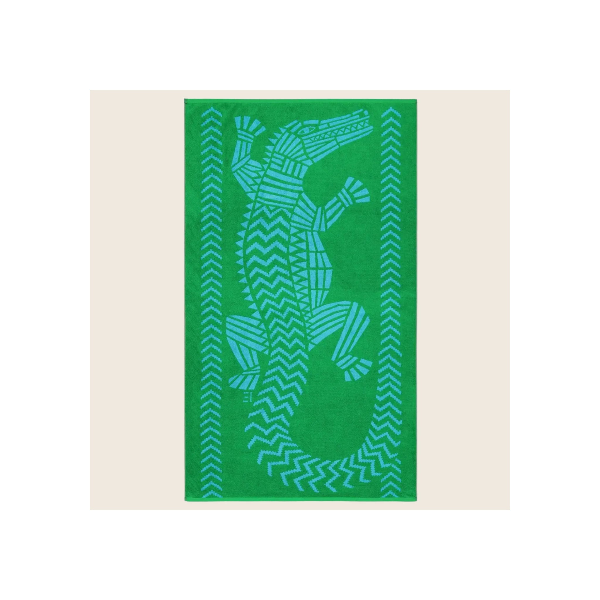 Beach towel in bright green with blue jacquard crocodile and chevron border pattern, laid flat