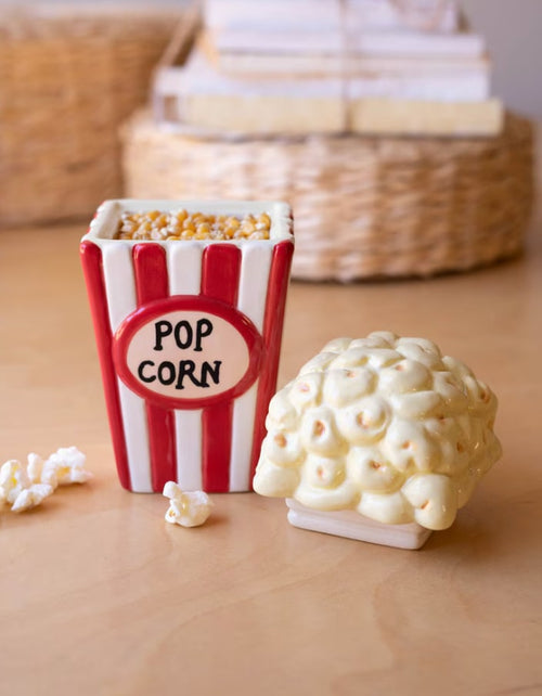Ceramic popcorn canister set, red-and-white striped container with popcorn-shaped lid, on wooden surface