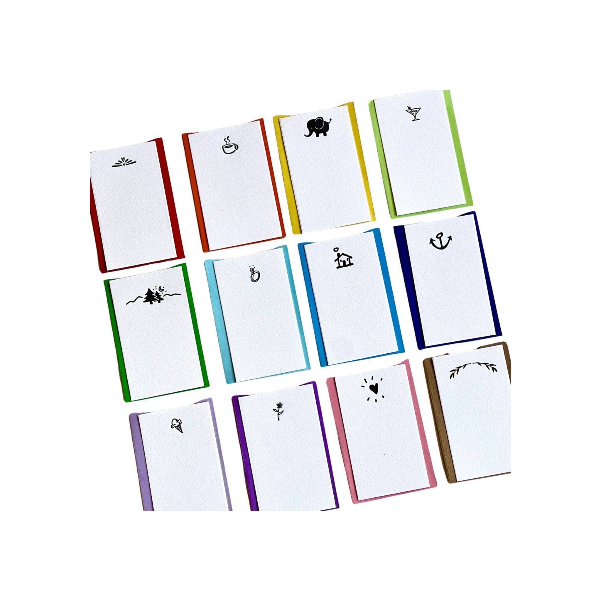 Assorted mini notepads with colorful spines and black icon designs, flat-lay arrangement on white background