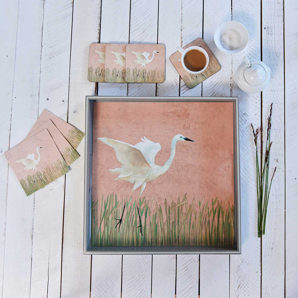 Square lacquer serving tray, terracotta-pink egret-in-reeds print, silver-edged frame, flat lay on white wood