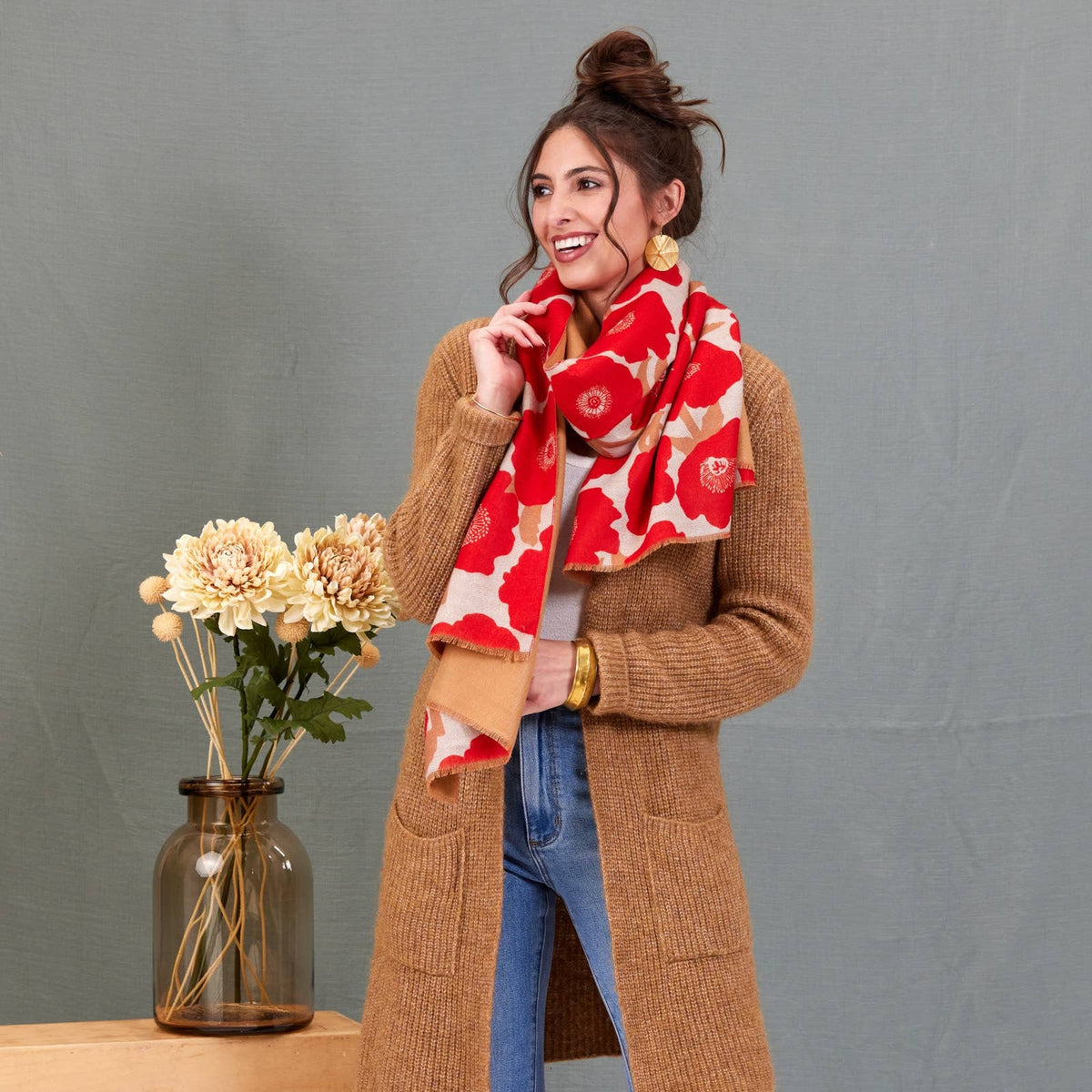 Scarf, red and cream large poppy print, reversible wrap, draped around model's neck over camel cardigan