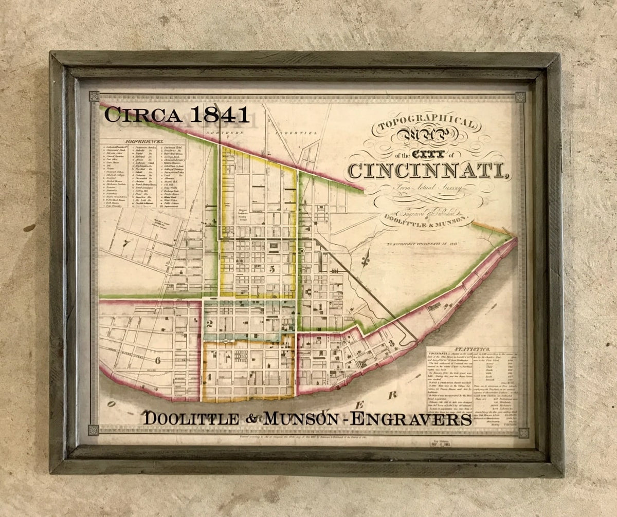 Framed Cincinnati 1841 topographical map, wood gray frame, hanging on textured wall