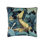 Cushion with tapestry-style woven otter amid teal and navy botanical foliage, black piped border