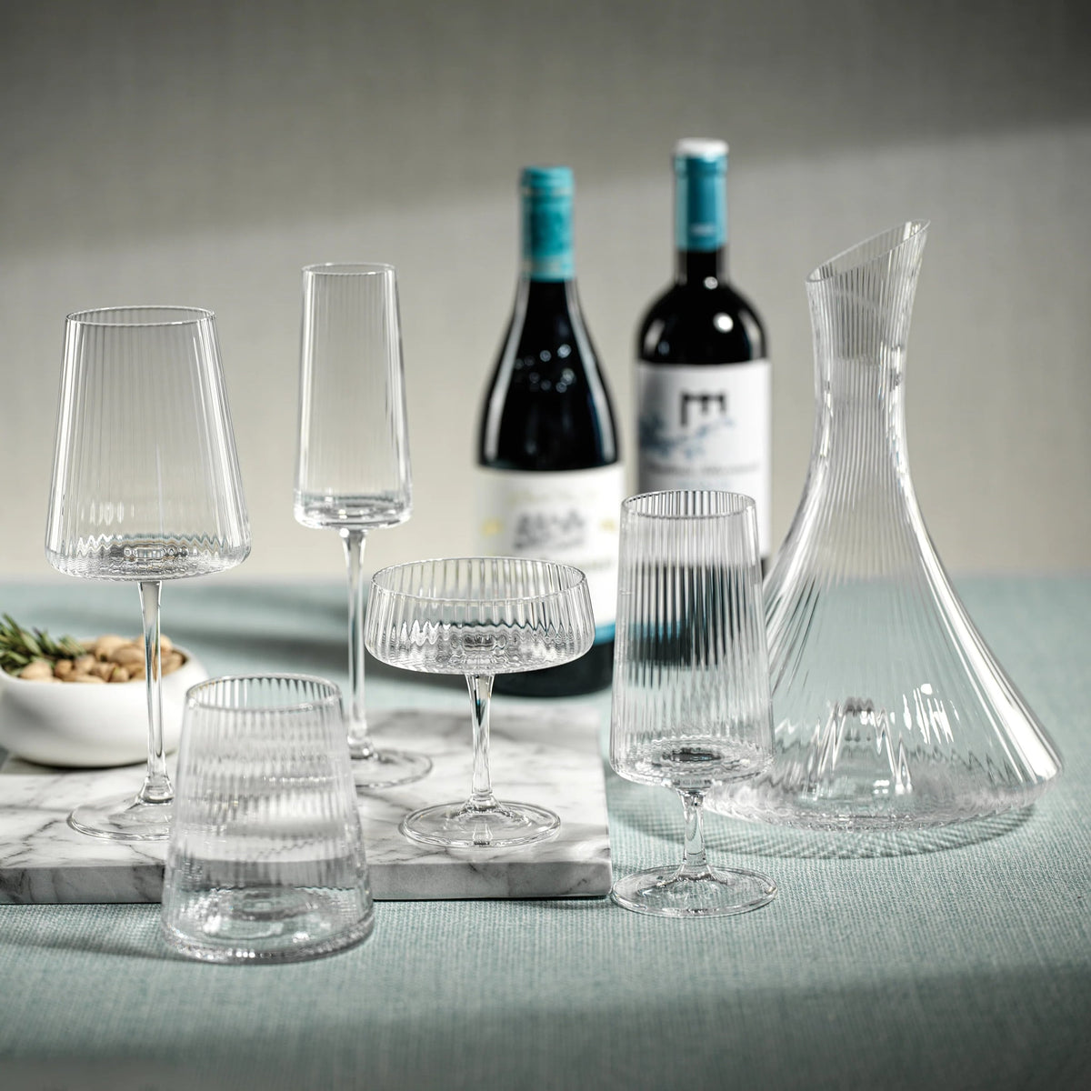 Bandol glassware collection, clear ribbed crystal, styled on teal linen with marble tray